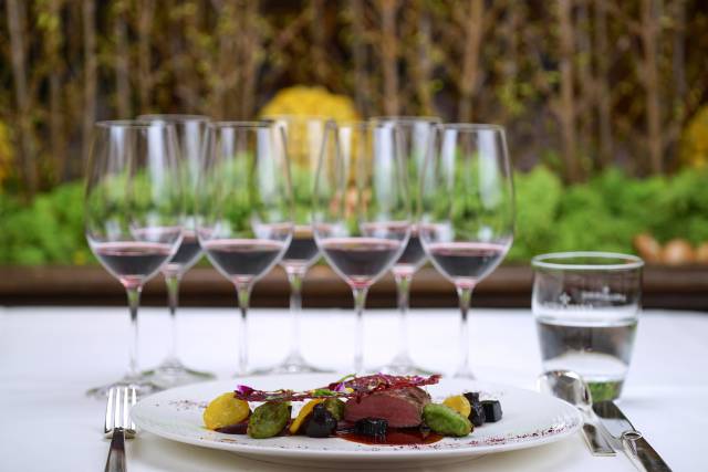 Rotweingläser und Essen auf Tisch im Landhotel Das Kronenschlösschen