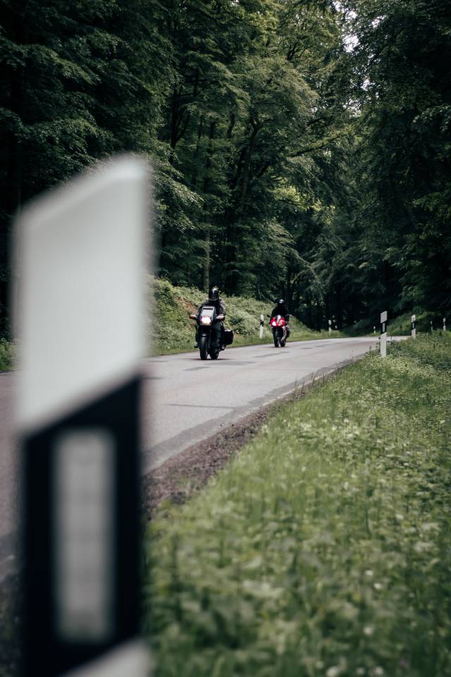 Motorradfahrer fahren durch den Wald